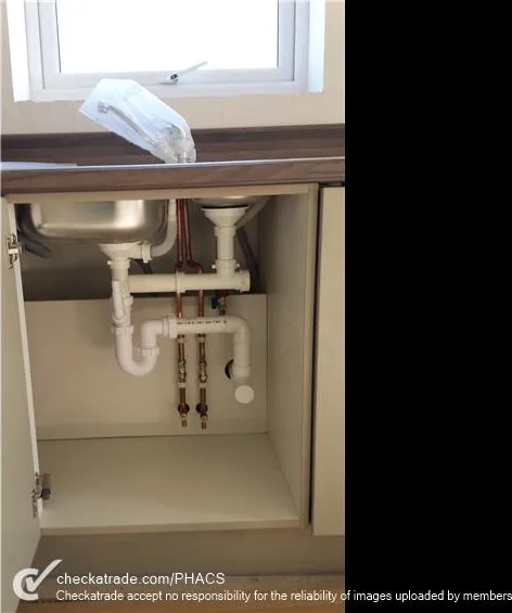 Under-sink plumbing and isolation valves neatly reworked by PHACS