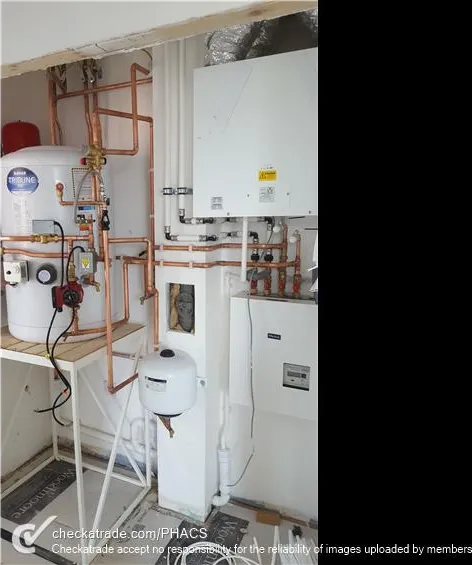 Boiler, cylinder and controls installed in a domestic plant cupboard